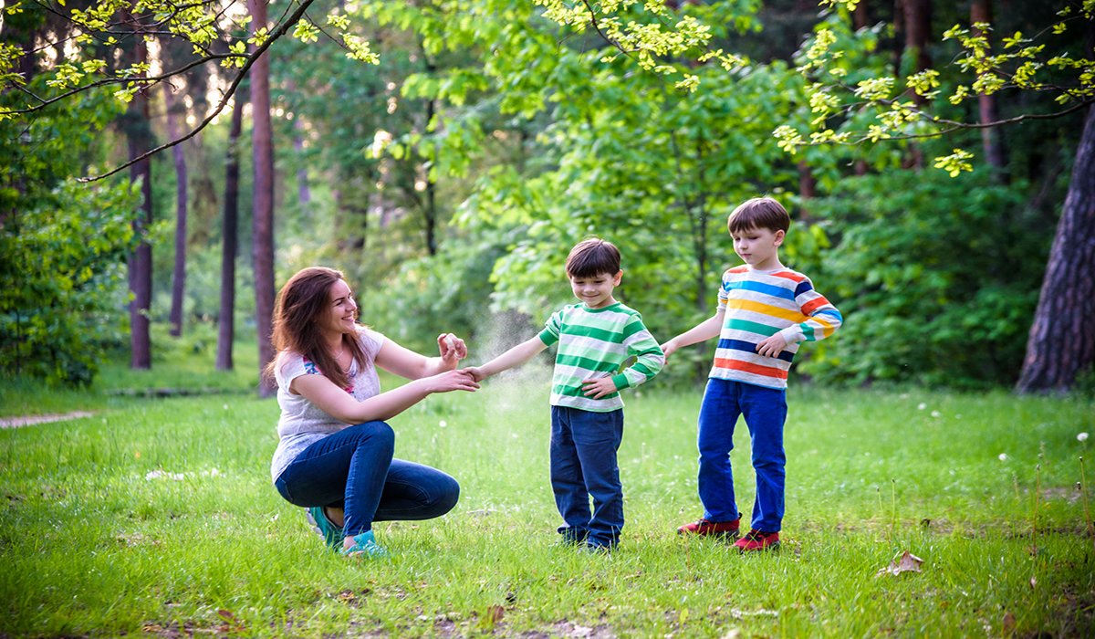 mom spraying kids with repellent